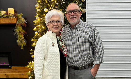 Drakes Farm Service employees standing in front of a Christmas tree 